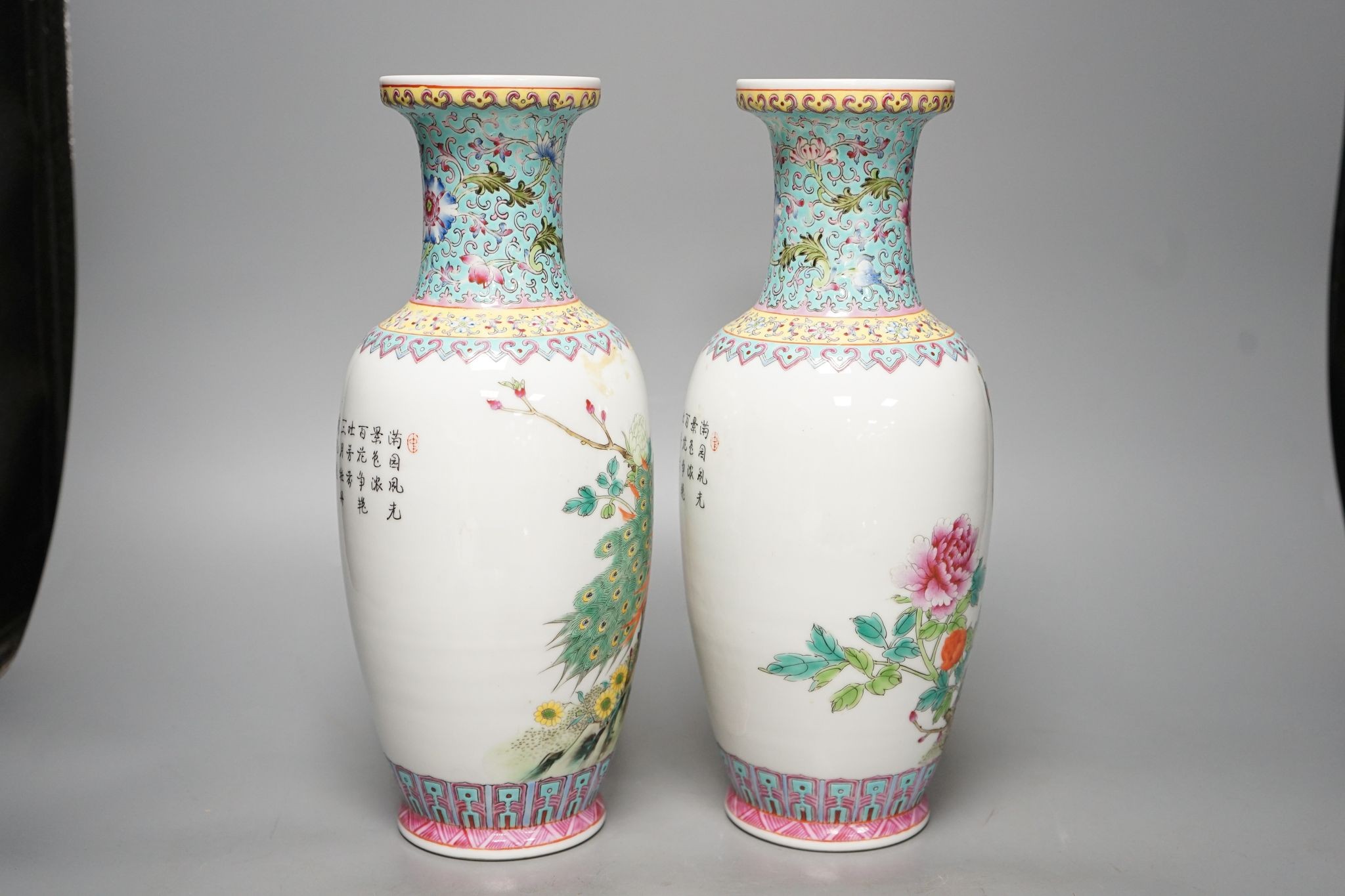 A pair of Chinese famille rose vases decorated with peacocks, 31cm